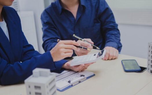 persone contrattano su spese condominiali in compravendita immobiliare